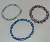 A collection of three shambala pearl bra