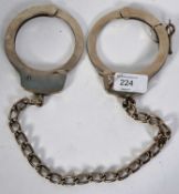 LEG IRONS: A pair of 20th century police style leg irons / cuffs.