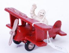 MICHELIN MAN: A 20th century cast iron advertising figure of the Michelin Man seated in a red