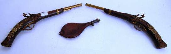 ARMS: A pair of reproduction decorative flintlock pistols, each with brass decorated barrels,