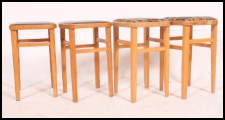 A set of 4 1970's beech wood utility kitchenette - diner stools raised on squared legs with