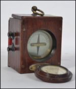 An early 20th century mahogany cased electrical meter with porthole cap having silvered dial with