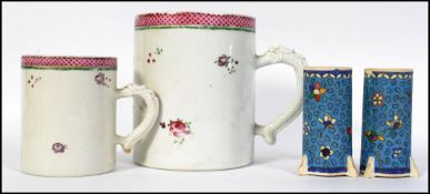 A pair of different sized 19th century hand painted Staffordshire mugs with Dragon handles,