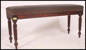 A Victorian style mahogany duet piano window stool seat with overstuffed seat being raised on