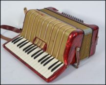 A vintage mid 20th century Hohner Arietta piano accordion, red pearloid finish,