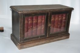 A Victorian table top bookcase cabinet raised on plinth base with twin doors containing a set of