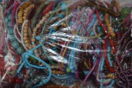 A large collection of bead bangles bracelets of differing styles and colours and bead types dating