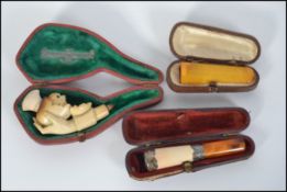 A cased amber cheroot holder along with a silver collared cased cheroot holder with a meerschaum