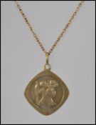 A 9ct gold St Christopher pendant on a rolled gold chain. Pendant weight 1.8g.