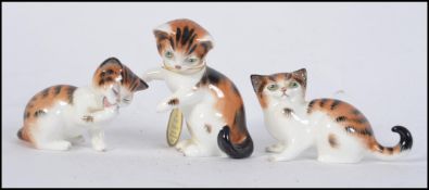 A small collection of three Royal Doulton sitting cats,