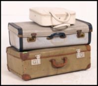A stack of vintage suitcases and a ladies vanity case together with 2 lambs wool retro style rugs.