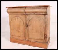 A Victorian country pine dresser base sideboard raised on bun feet with twin door cupboard having