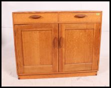 A mid century light solid oak sideboard in the manner of Heals on inset plinth base having two