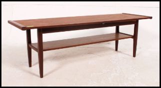 A vintage / retro 1970's surfboard style teak coffee table raised on turned legs with magazine rack