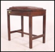 A Victorian oak duet / piano stool raised on tapered square legs with upholstered seat with hinged