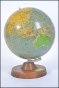 A retro 1985 political desk top globe being raised on a wooden plinth base.