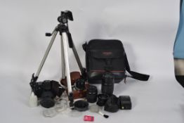 A cased Canon EOS 888 35mm camera with a selection of lenses to include a canon zoom lens 100-200mm,