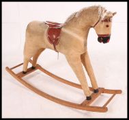 A retro 1970's corduroy rocking horse with saddle and stirrups raised on wooden rockers