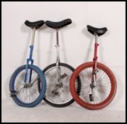 3 20th century retro unicycles of varying colours by Pashley to include Red,