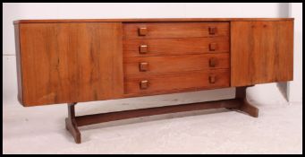 A 1970's retro teak wood Danish influence sideboard raised on tapered supports having bow shaped