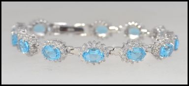 A beautiful silver white metal blue topaz daisy style ladies bracelet,
