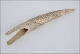 An early 20th century carved Ivory tusk in the form of a crocodile having scaled body with hollow