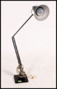 A pre war 1930's Black Herbert Terry anglepoise desk lamp being raised on graduating square plinth