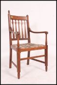 A 1920's Arts & Crafts large oak carver dining chair being raised on turned legs united by