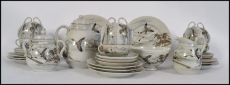A Japanese translucent tea service with flowing dragon decoration, to include cups, saucers, teapot,