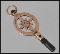 An unmarked gold fob watch winding key tests 14ct gold with pierced decoration. Measures 3cms.