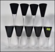 A set of 20th century coloured glass wine glasses each with purple glass trumpet bowls on clear
