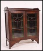 A good early 20th century oak arts & crafts leaded and coloured glass bookcase cabinet.