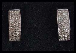 A pair of 9ct white gold and diamond hoop earrings. Weight 3.