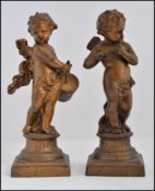 2 Victorian gilded spelter figurines of cherub - putti playing musical instruments - each raised on