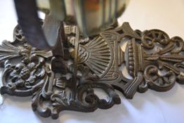 A Victorian cast iron door architectural wall mounted brass oil lamp with large ring supporting the