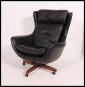 An original 1960's believed Parker Knoll black Batwing swivel chair - armchair being raised on teak