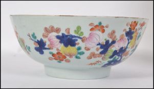 A 19th century Chinese bowl having hand painted floral design and with an early riveted repair.