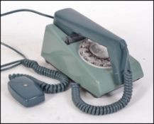 A retro trim phone circa 1970 with rotary dial on an unusual teal/green/blue plastic body and