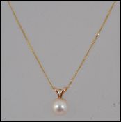 A 9ct gold pendant necklace with pearl pendant on a fine 9ct gold chain. Marked 375 Tests 9ct.