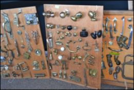 A fabulous collection of 3 boards of mounted handles, hinges, doorknobs,