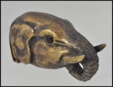 A 20th century brass vesta case in the form of an elephants head having hinged base and striker