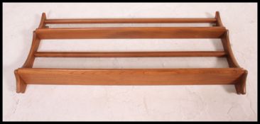 A 20th century Golden Dawn two tier Ercol plate rack with applied blue Ercol sticker to the rear.