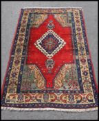 A Turkish handwoven rug of colourful form with central red medallion having geometric scrolling