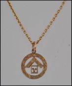 A hallmarked 9ct gold Masonic pendant strung on a 15ct gold chain with clip barrel clasp marked