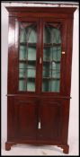A large 19th century mahogany corner cabinet having twin door astragal front with carved lattice