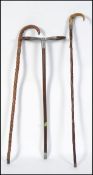 A 20th century shooting stick along with two silver collared walking sticks both having tapering