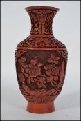 A Chinese Cinnabar style red laquered brass vase having decorative design in relief work of