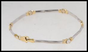 A 14ct gold and white gold ladies bracelet of twist bar link form complete with the clasp.