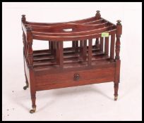 A Victorian mahogany canterbury - magazine stand being raised on turned legs with brass cup castors