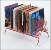 A collection of 45rpm single records along with a vintage / retro record rack